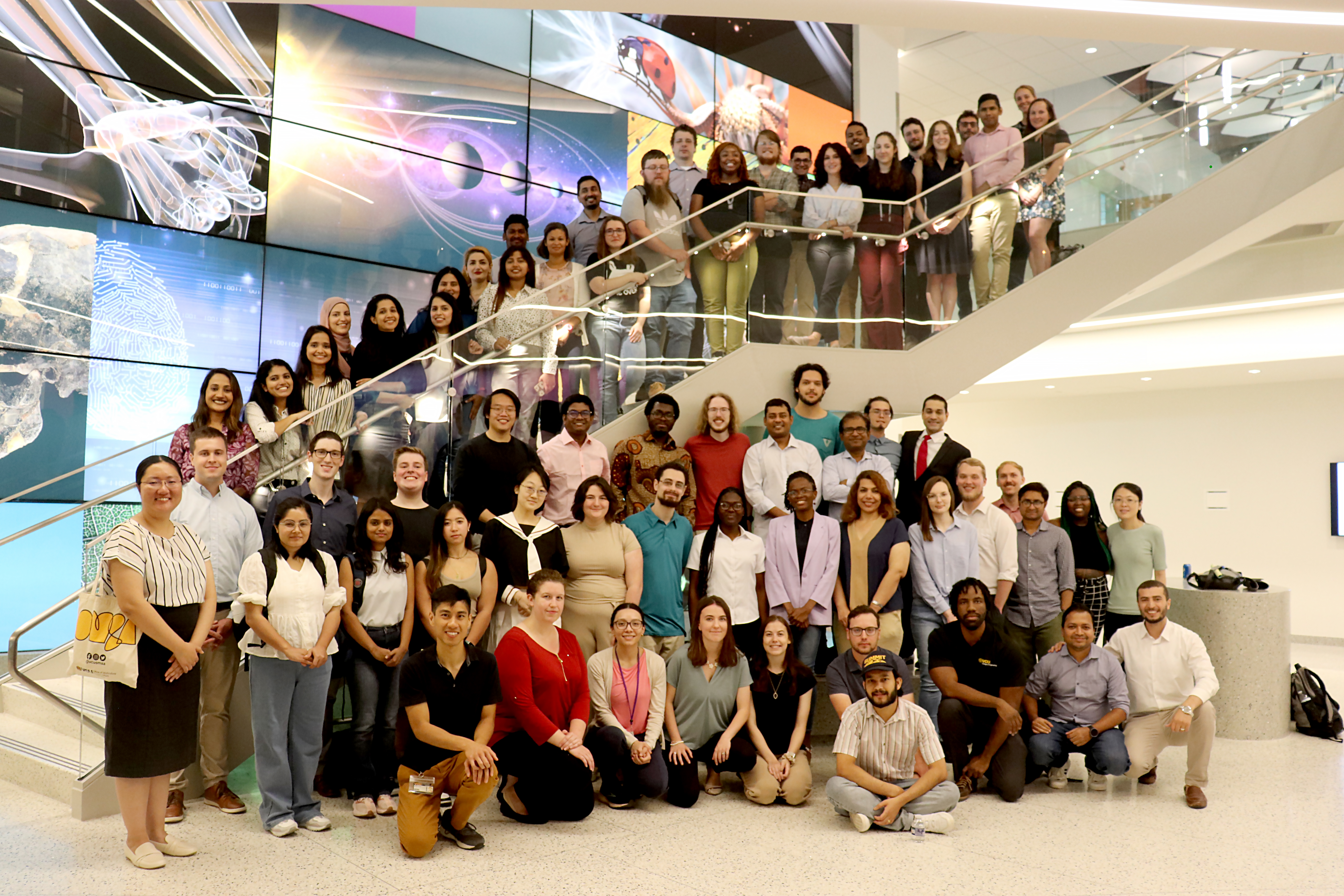 A large group of graduate students standing on a staircase in the STEM Building