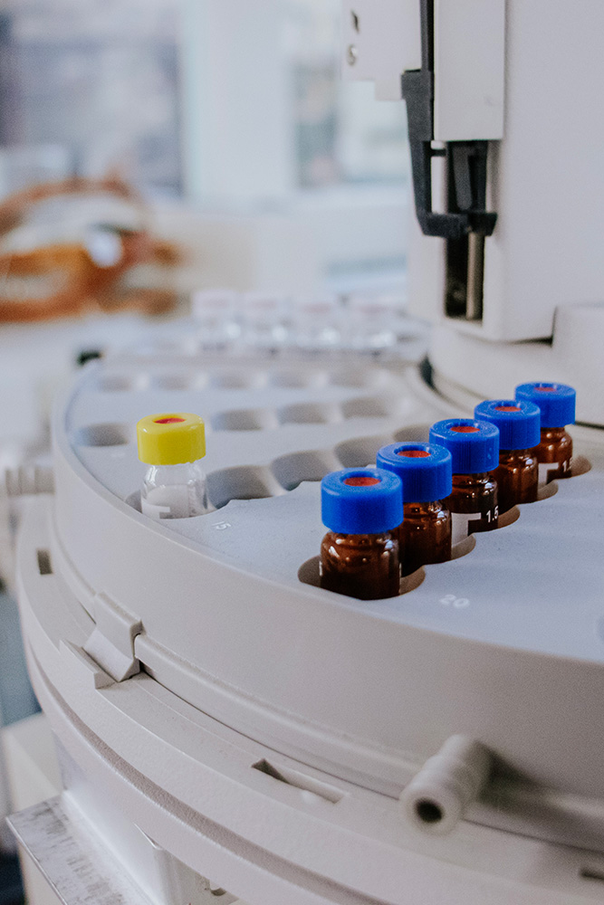 A batch of vials sit inside equipment in a chemistry lab